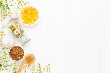 Doğal kozmetik ürünleri ve açık arkaplanda papatya çiçekleri ile kompozisyon aroması.