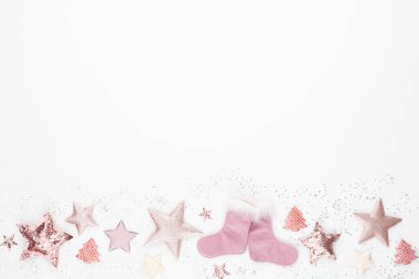 Noel minimalist ve pembe renkte basit bir kompozisyon. Noel yıldızı, beyaz arka planda süslemeler. Düz konum, kopyalama alanı olan üst görünüm