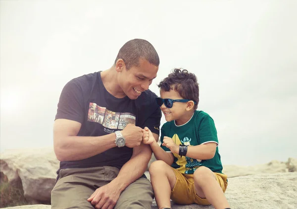 Mutlu gülümseyen baba ve oğul portresi hoş bir gülümseme oturan ve birbirlerine yumruk yumruğa vermek. olumlu ifadeler var, dostça bir ilişki göstermek. İnsanlar ve aile ve yaşam tarzı babalar günü kavramı