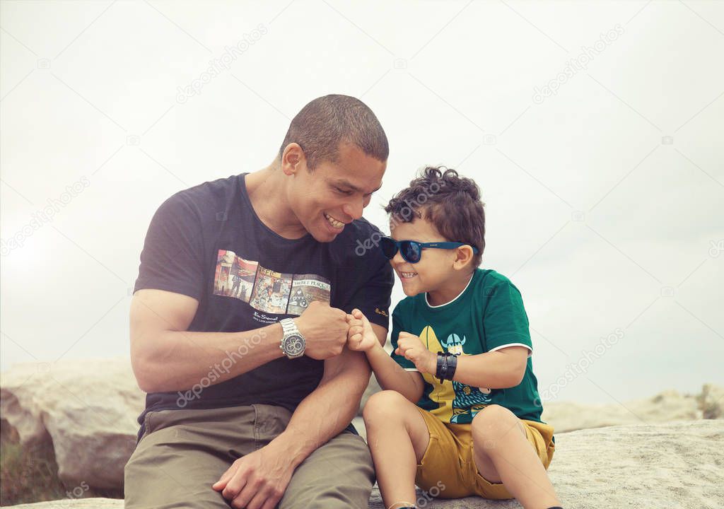 Portrait of happy smiling father and son with pleasant smile sitting and give fist bump to each other. have positive expressions, demonstrate friendly relationship. People and family and lifestyle father's day concept