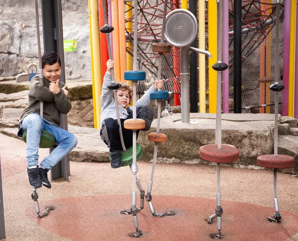 İki kardeş parkta oyun parkına tırmanırken eğleniyorlarmış.