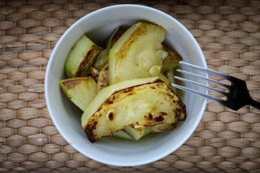 Hasır arka plan yakın çekim üzerinde beyaz bir tabak kızarmış kabak