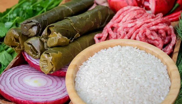 Dolma yemek pişirmek için malzemeler. Kıyılmış et, taze yaprak, tereyağı, pirinç, soğan, nar.
