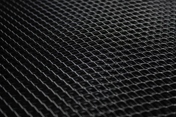 black metal mesh under dim light source. Background