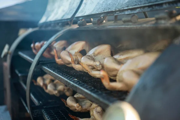 Cucinare pollo in una griglia enorme. Caffè all'aperto Foto Stock