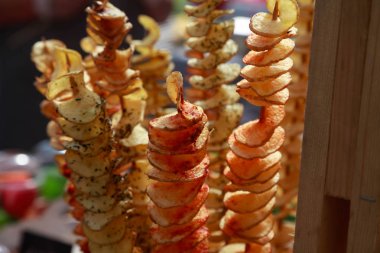 Bir sopanın üzerinde patates cipsi. Doğal cipsler kızartılır ve fuarda satılır.