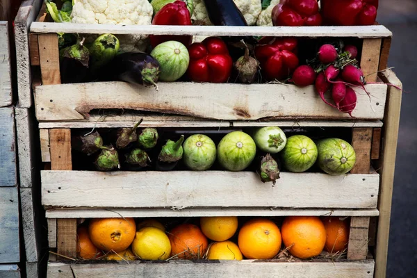 Various kinds of fruits and vegetables arranged in wooden boxes, offer at the farmers market — Stock Photo, Image
