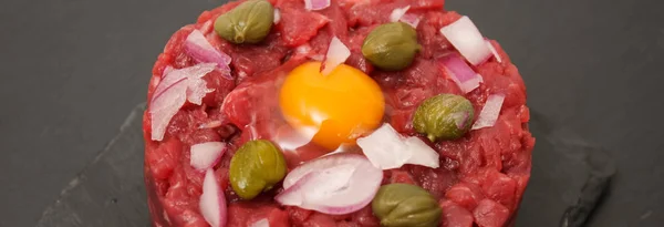 Fresh beef tartare with egg and capers, close-up. — Stock Photo, Image
