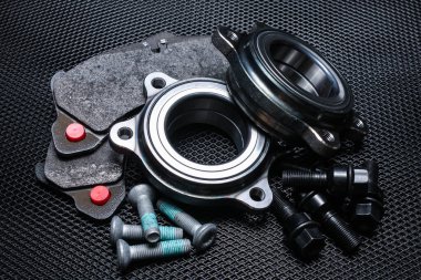 Siyah arkaplandaki otomobil parçaları. Fren pedleri, mil yatakları, bağlayıcılar. Black Metal ağ arkaplanı