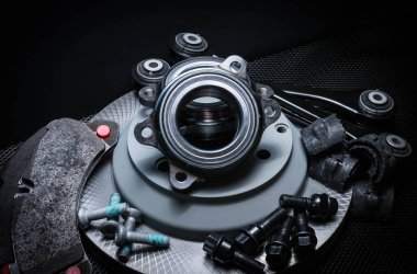 Birçok araba parçası çalışıyor: fren diski, pedallar ve bağlantı cihazlarıyla bağlantı noktası, siyah arka planda izole edilmiş..