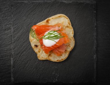 Krep üzerine dereotlu somon balığı. Siyah bazalt plaka.