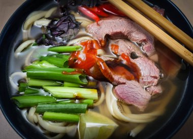 Pho Bo - Vietnam usulü taze pirinç çorbası biftek, ot ve fesleğen. Vietnam 'ın ulusal yemeği. yakın çekim görünümü