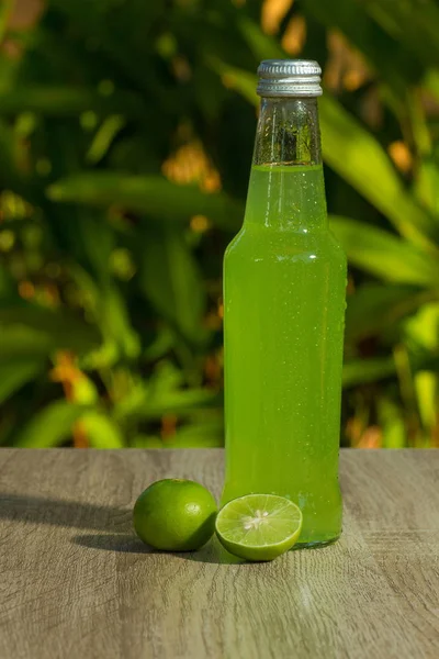 Bottle with  drink  and limes on background