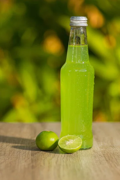 Bottle with  drink  and limes on background