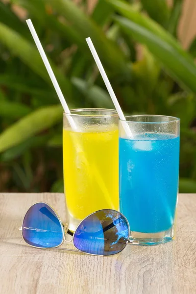 glasses with drinks stand on a table on a green background