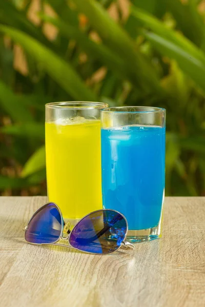 glasses with drinks stand on a table on a green background