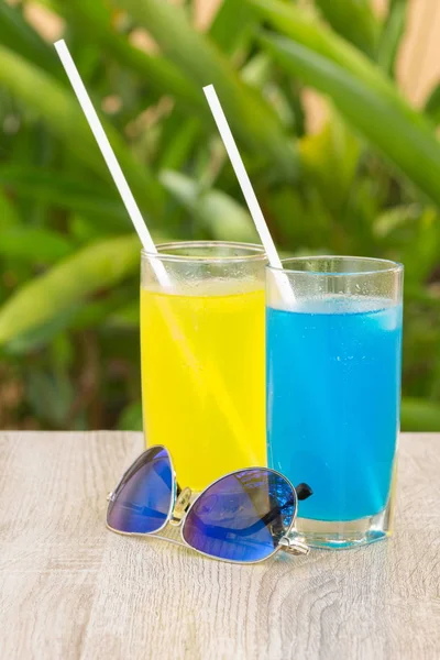glasses with drinks stand on a table on a green background