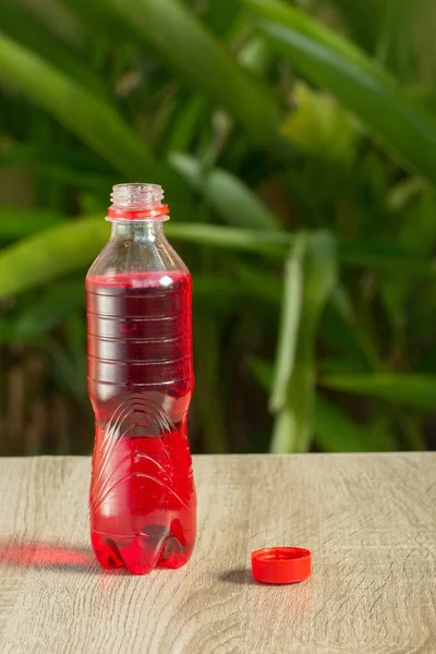 bottle with drink stand on a table on a green background