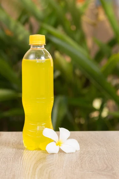 bottle with drink stand on a table on a green background