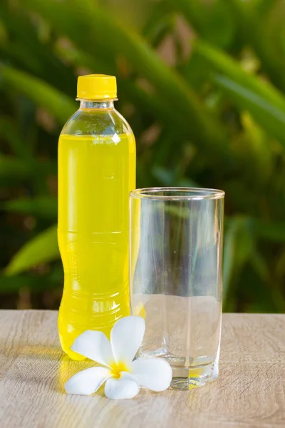 bottle with drink stand on a table on a green background