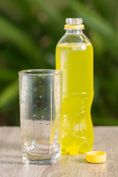 bottle with drink stand on a table on a green background