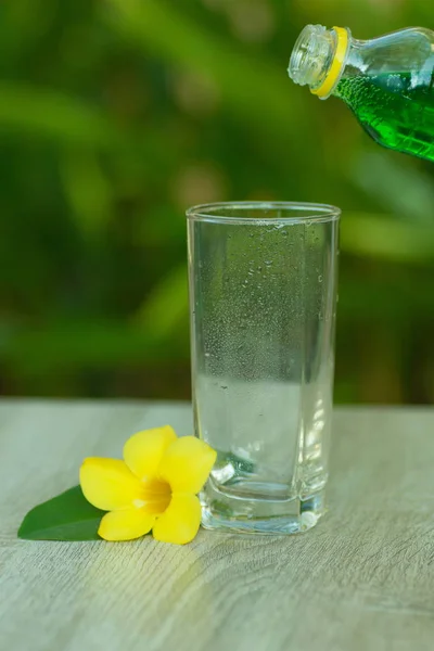glass with  drink stand on a table on a green background