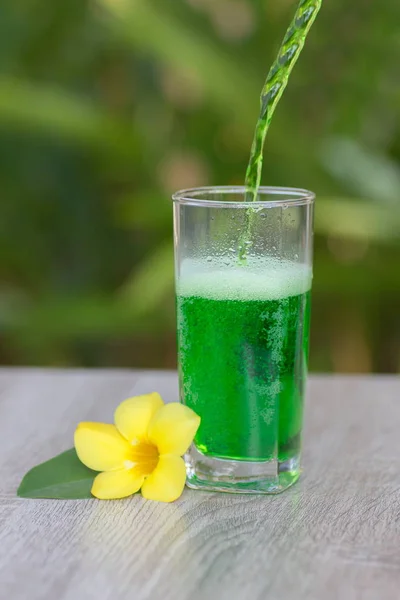 glass with  drink stand on a table on a green background