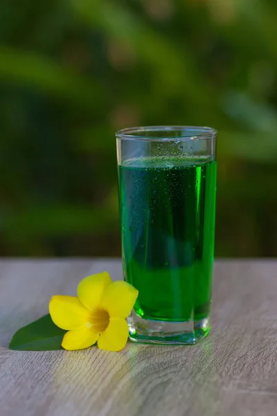 glass with  drink stand on a table on a green background