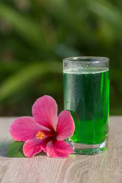 glass with  drink stand on a table on a green background