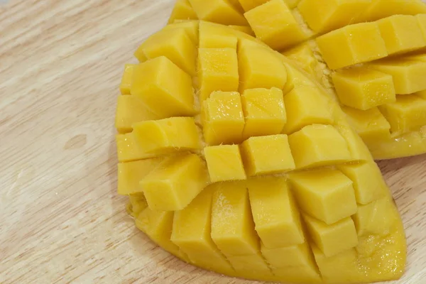 The mango fruit is cut into cubes on  background