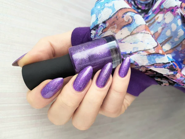 Female hand with violet long nails