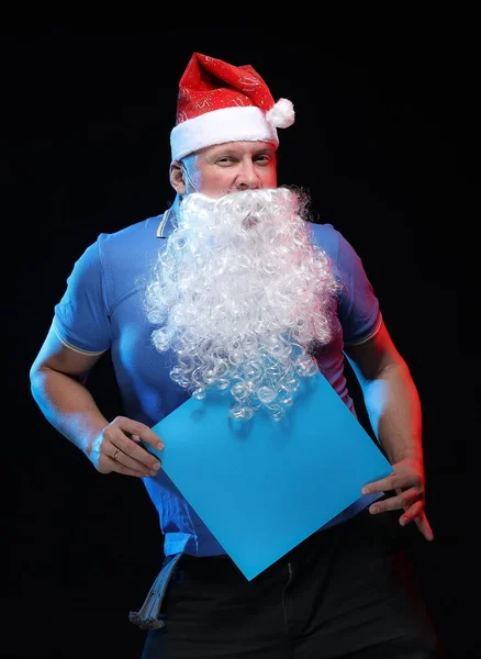 portrait actor male in cap and beard of Santa Claus on a black background