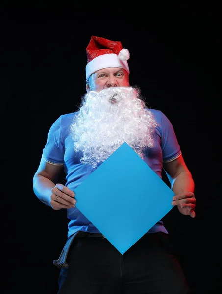 portrait actor male in cap and beard of Santa Claus on a black background