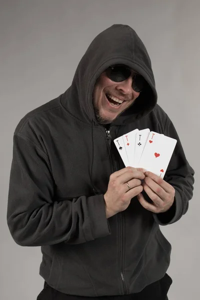 man holds a deck of cards and shows tricks in a scenic light