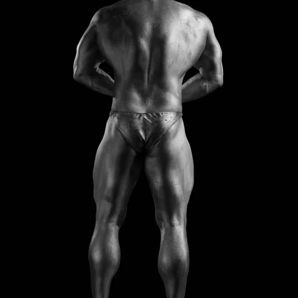 Black and white portrait of male athlete bodybuilder posing on a black background