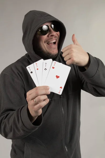 man holds a deck of cards and shows tricks in a scenic light