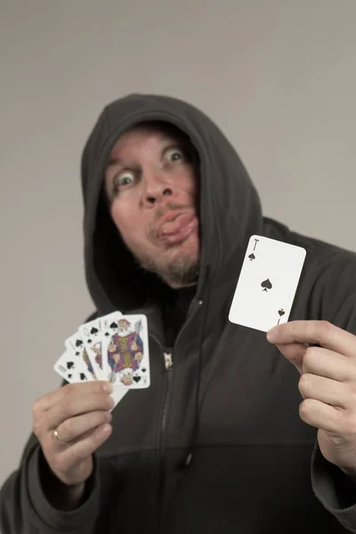 man holds a deck of cards and shows tricks in a scenic light