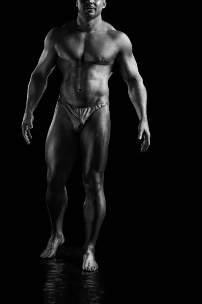 Black and white portrait of male athlete bodybuilder posing on a black background