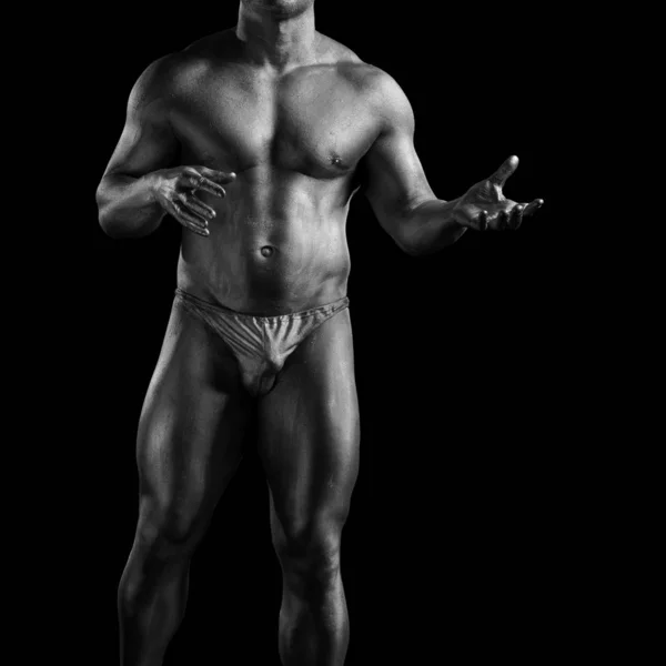 Black and white portrait of male athlete bodybuilder posing on a black background