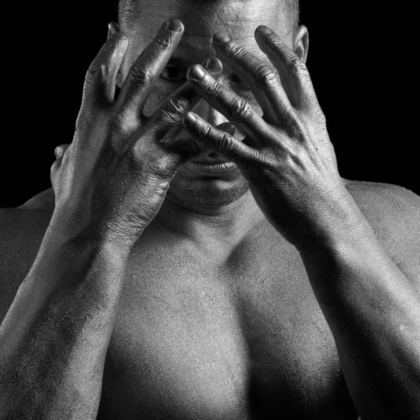 Black and white portrait of male athlete bodybuilder posing on a black background