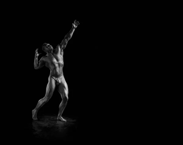 Black and white portrait of male athlete bodybuilder posing on a black background