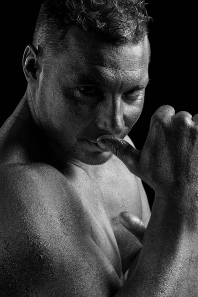 Black and white portrait of male athlete bodybuilder posing on a black background