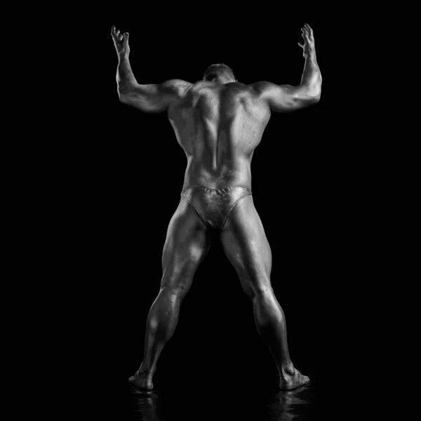 Black and white portrait of male athlete bodybuilder posing on a black background