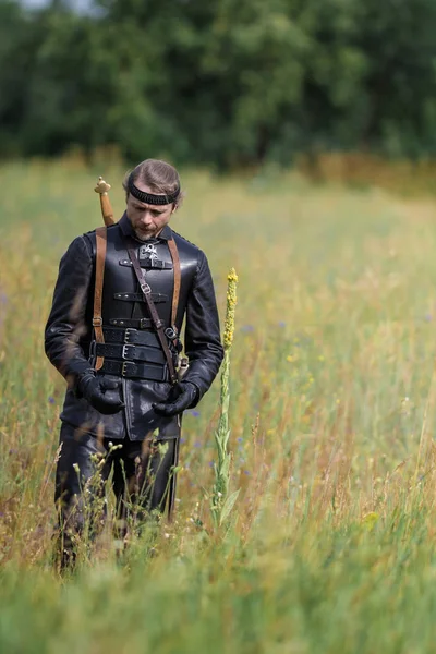 Man actor in the historical leather costume of a knight from the fantasy games