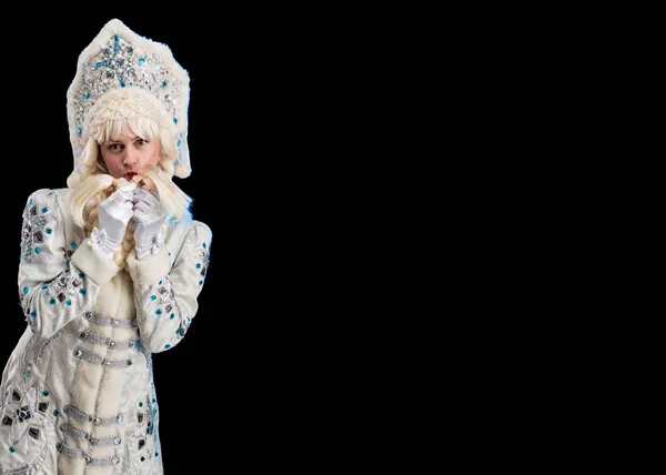 Snow Maiden in a white fur coat and kokoshnik poses on a black background