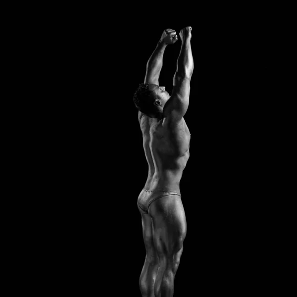 Black and white portrait of male athlete bodybuilder posing on a black background