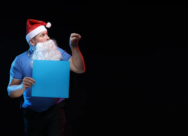 portrait actor male in cap and beard of Santa Claus on a black background