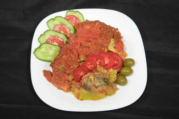 close-up view of tasty stewed dish with vegetables on white plate