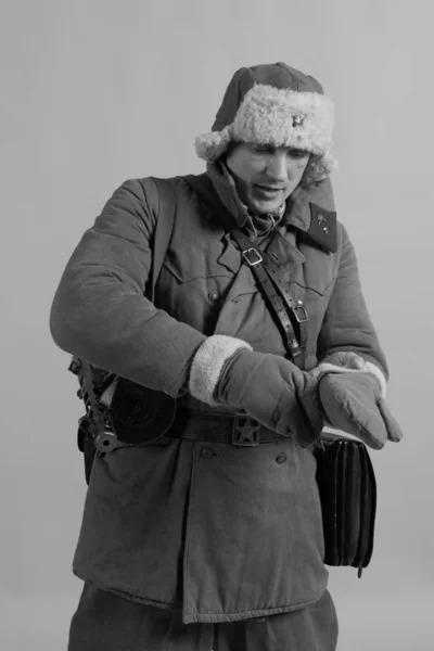 male actor in winter uniform a Russian soldier of the Red Army, a period of 1942 the second world war, posing on  background