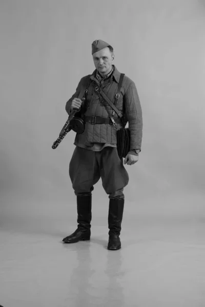 male actor in the winter uniform of an officer of the Red Army period World War II posing on background